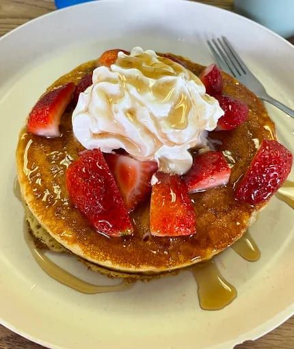 Pancakes topped with strawberries and whipped cream